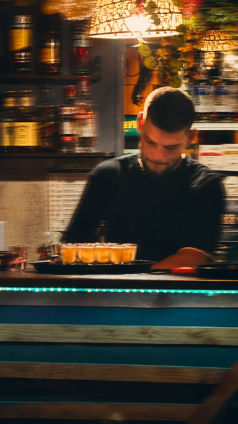 Ownerul WRS pregătește shoturi la bar — fotografie cu tratament cinematic de mișcare