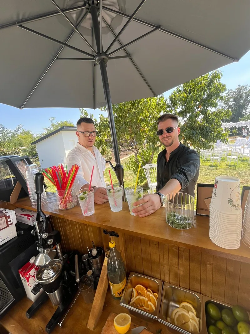 Două persoane la barul WRS, cu fețele și cocktailurile vizibile în întregime
